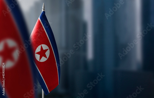 Small flags of North Korea on a blurry background of the city photo
