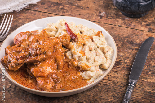 Chicken stew with paprika and cream on a plate with Hungarian gnocchi on a plate - chicken paprikash.
