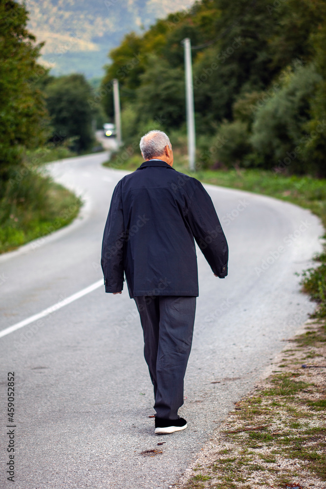 Happy senior man walking on the road line Happy senior man walking on the road line