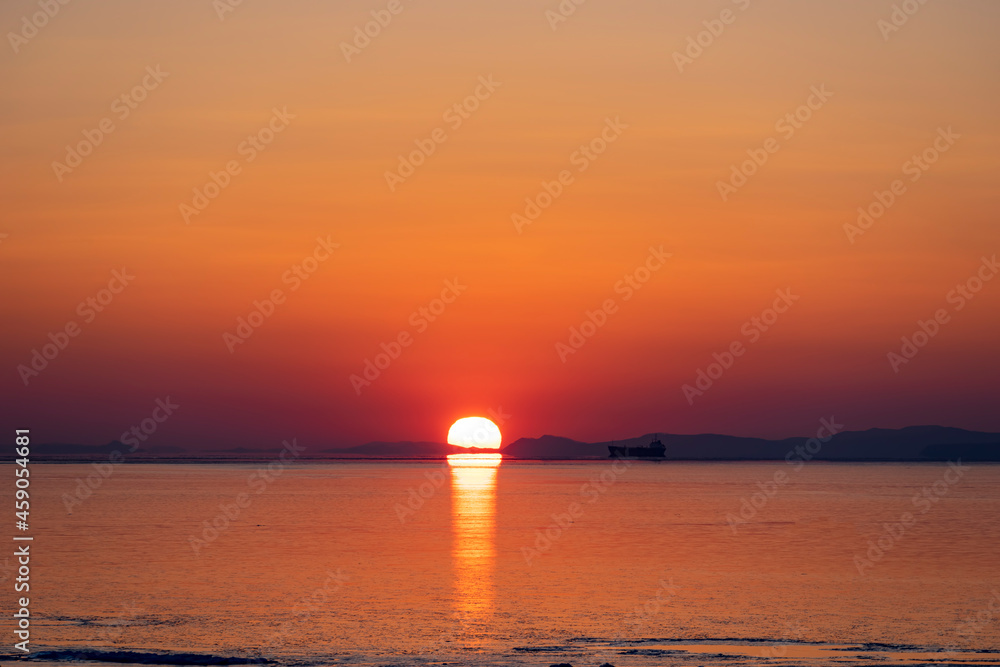 Beautiful sunset over the sea and the silhouette of the ship