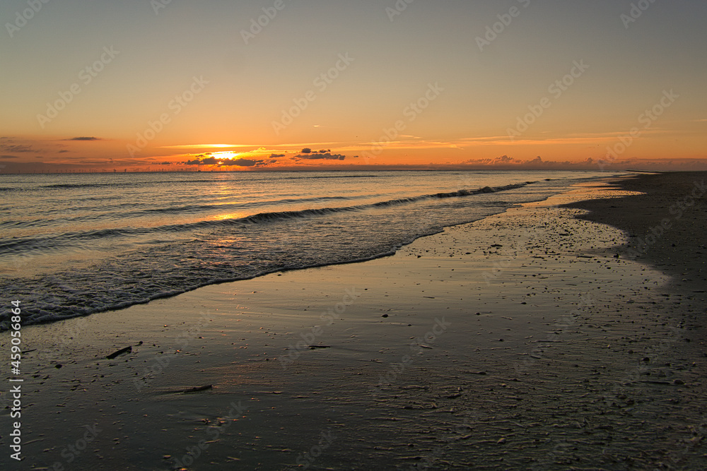 Sunset on the beach of Blåvand in Denmark. Walking in the evening in great light atmosphere