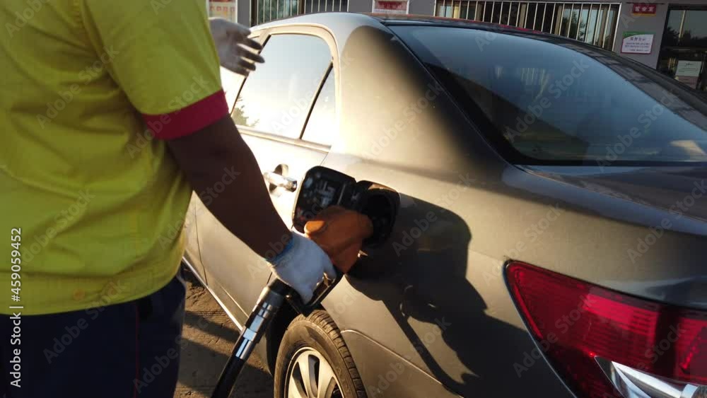 Gas station worker refueling the car Gas station worker refueling the car