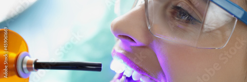 Εκτύπωση καμβά Doctor dentist shining on teeth of female patient curing light closeup