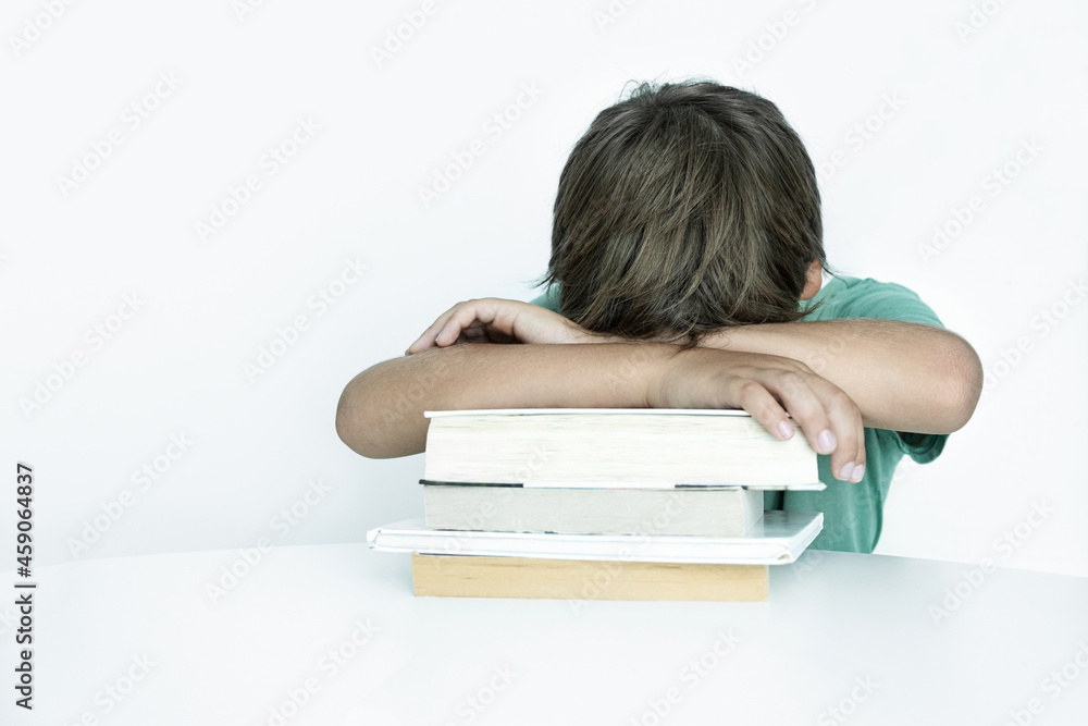 Sad boy with book does school homework. Back to school. Unhappy schoolboy with textbooks. Distance learnin Sad boy with book does school homework. Back to school. Unhappy schoolboy with textbooks. Distance learnin