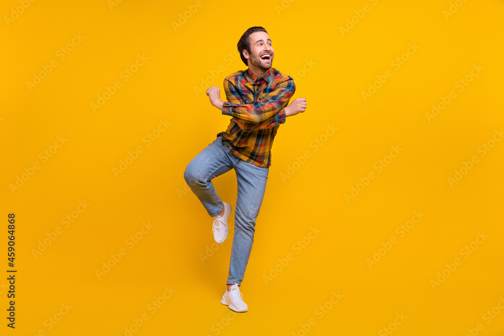 Full body photo of cute brunet young guy dance wear shirt jeans sneakers isolated on yellow background Full body photo of cute brunet young guy dance wear shirt jeans sneakers isolated on yellow background