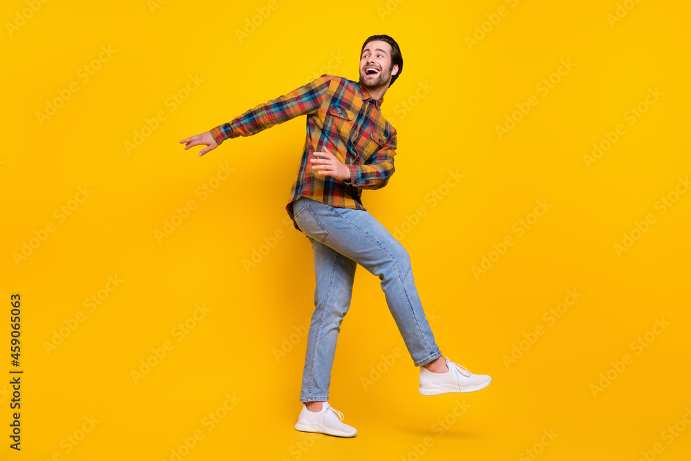 Fototapeta premium Full size photo of joyful brunet millennial guy dance wear shirt jeans sneakers isolated on yellow background