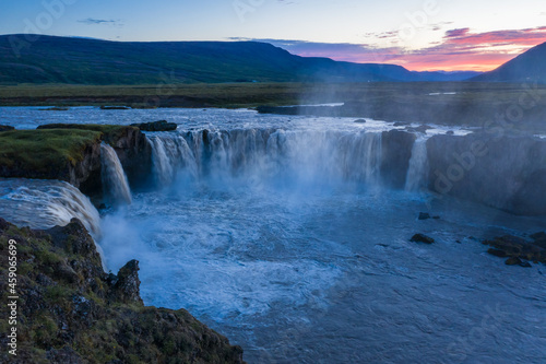 The aerial view of the beautiful waterfall of Godafoss at link sunset, Iceland in the summer season © Igor Tichonow