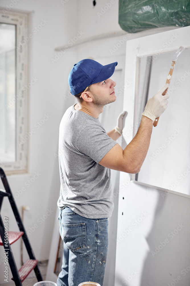 Young adult man working on a DIY budget renovation of his new home apartment.