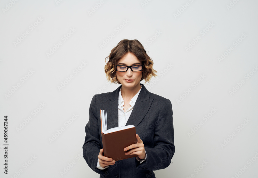 woman in business suit notebook in hand light background woman in business suit notebook in hand light background