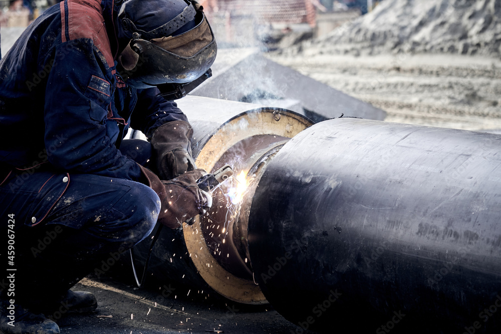 Construction worker arc welding the metal pipe. Construction worker arc welding the metal pipe.