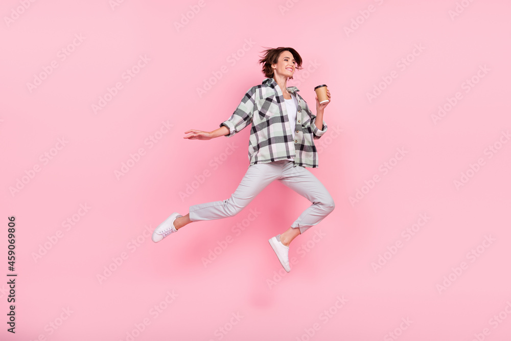 Full length photo of sweet millennial brunette lady run hold coffee wear shirt trousers shoes isolated on pink background