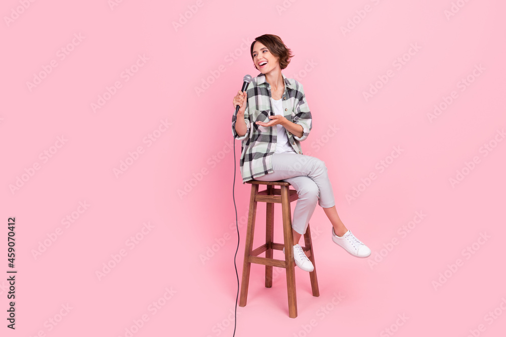 Full length photo of funky young brunette lady sit talk wear shirt trousers isolated on pink background Full length photo of funky young brunette lady sit talk wear shirt trousers isolated on pink background