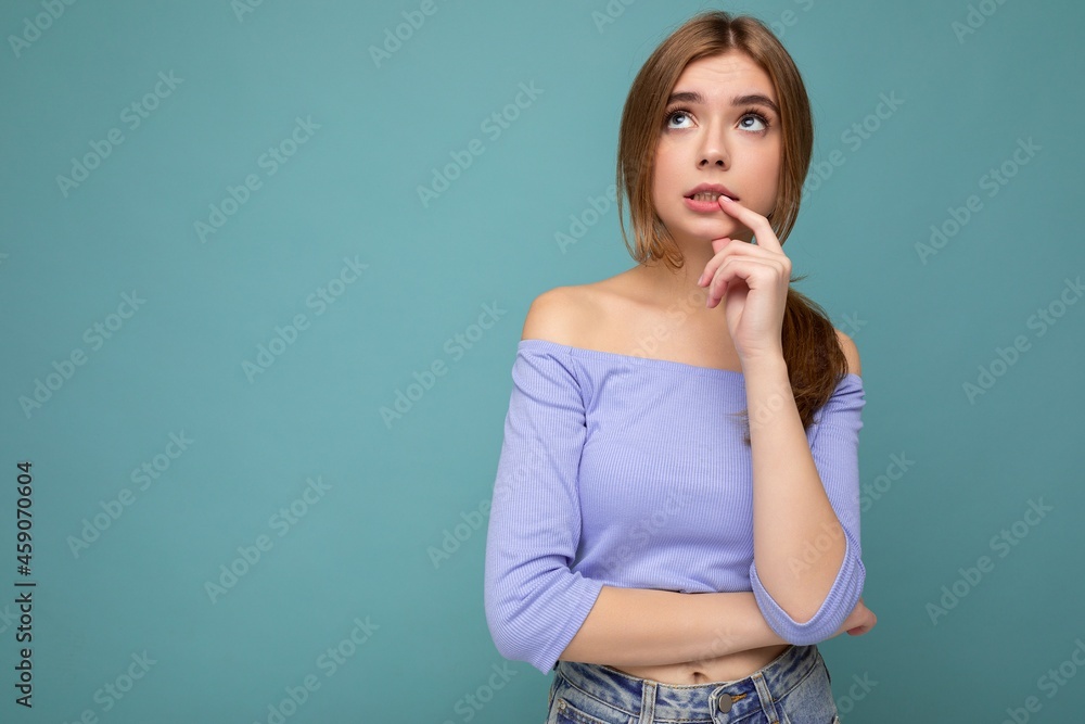Photo portrait of thoughtful young nice beautiful blonde lady with sincere emotions wearing trendy blue crop top isolated over wall with empty space and thinking Photo portrait of thoughtful young nice beautiful blonde lady with sincere emotions wearing trendy blue crop top isolated over wall with empty space and thinking