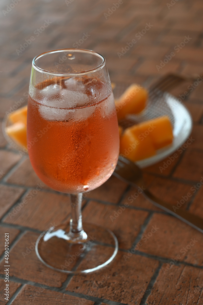 Verre de rosé avec une assiette de morceaux de melon Verre de rosé avec une assiette de morceaux de melon
