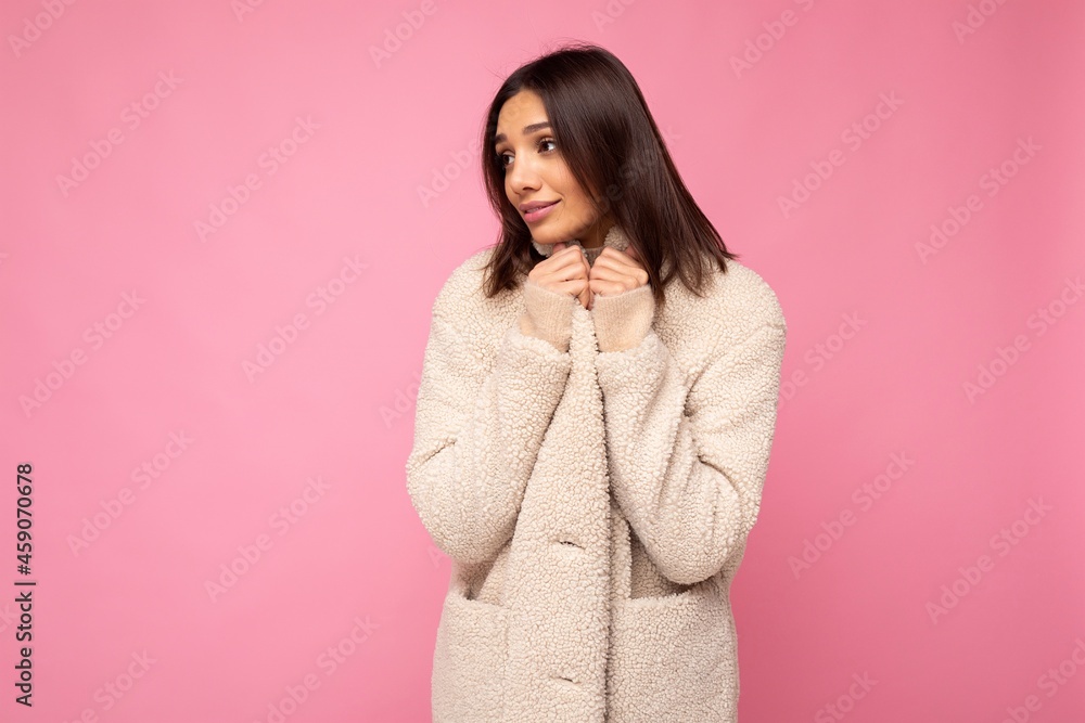 European beautiful young brunette woman wearing stylish beaige warm coat isolated over pink background with copy space European beautiful young brunette woman wearing stylish beaige warm coat isolated over pink background with copy space
