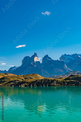 Peaks of Torres seen from Pehoe Lago with turquoise water in Torres del Paine National Park, Patagonia, Chile, at sunny day and blue sky. © neurobite