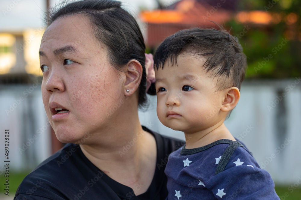 portrait image of A Chinese mother carry her Happy and cute Asian Chinese baby boy at park during evening portrait image of A Chinese mother carry her Happy and cute Asian Chinese baby boy at park during evening