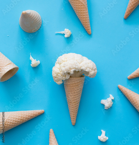 Cauliflower pretending to be an ice cream, inside a cone.
