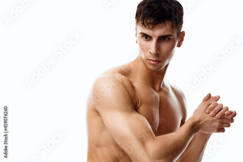 nude male athlete with an inflated torso gesturing with his hands side view