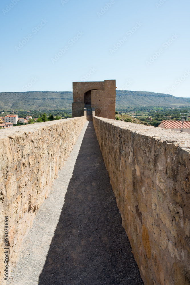 Long open corridor to a stone tower. Mora de Rubielos, Teruel, Aragon, Spain