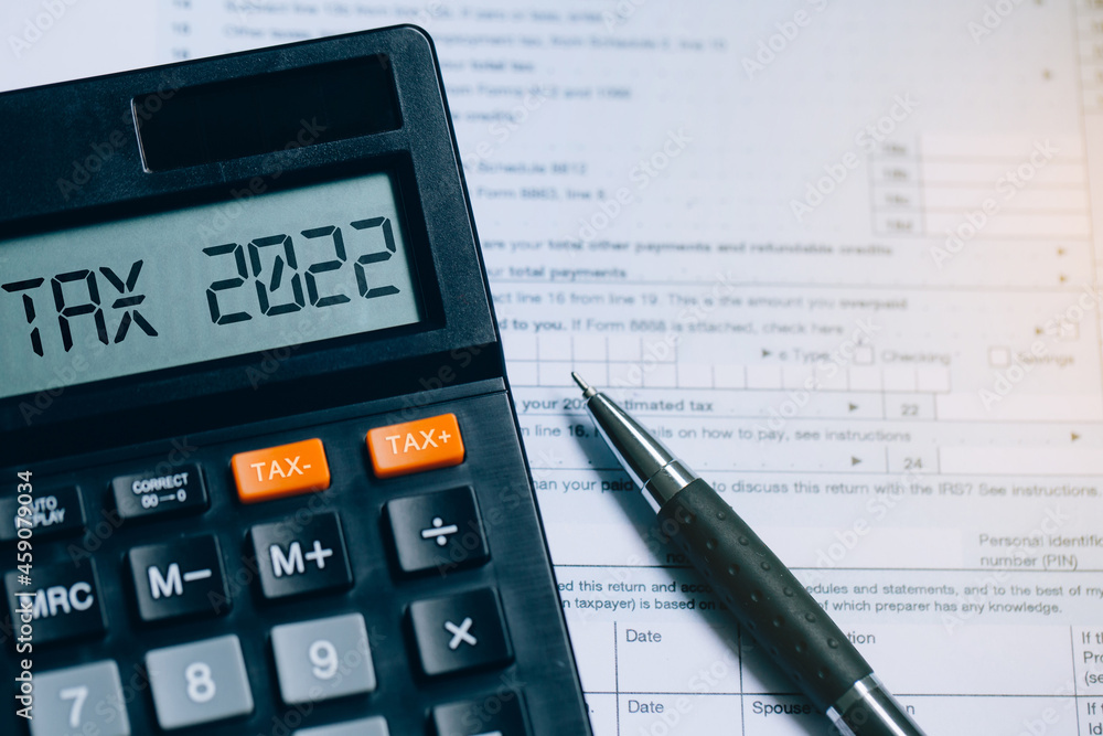 Word Tax 2022 on the calculator on documents.Income Statement. paying the tax rate. Taxation, taxes burden.Business and tax concept. Word Tax 2022 on the calculator on documents.Income Statement. paying the tax rate. Taxation, taxes burden.Business and tax concept.