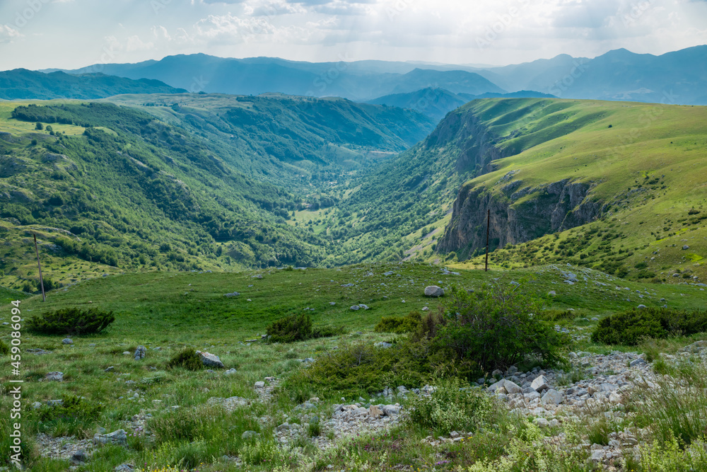 Naklejka premium Mountains peaks of the Durmitor National Park, along which picturesque high-mountain tourist road of northern Montenegro passes. UNESCO World Heritage site. Beautiful summer cloudy landscape.