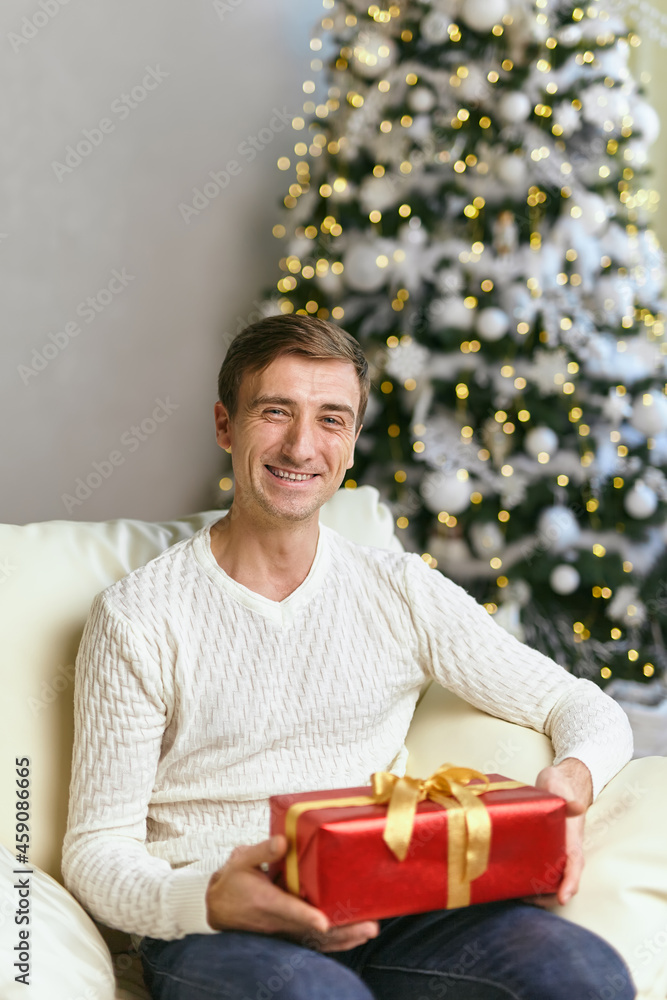 Happy young man holding present in christmas time. Happy young man holding present in christmas time.