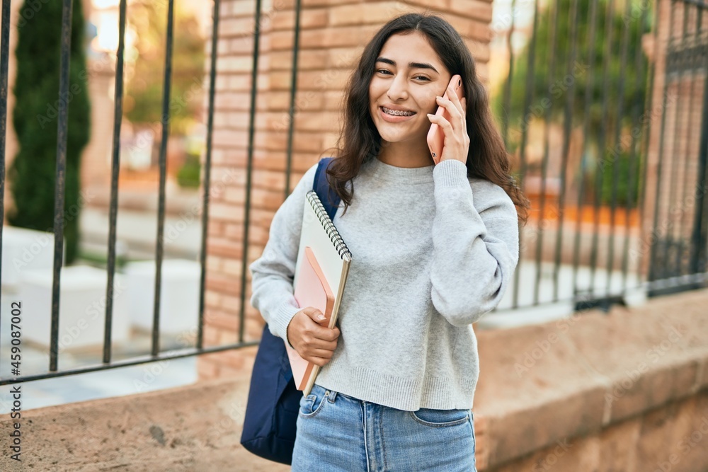 Young middle east student girl smiling happy talking on the smartphone at the city. Young middle east student girl smiling happy talking on the smartphone at the city.