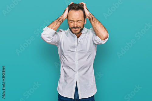 Middle age man wearing casual clothes suffering from headache desperate and stressed because pain and migraine. hands on head.