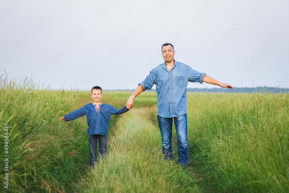 A Happy child with parent on shoulders walk along the road in park background