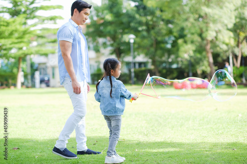 Happy asian family together with daughter in playground