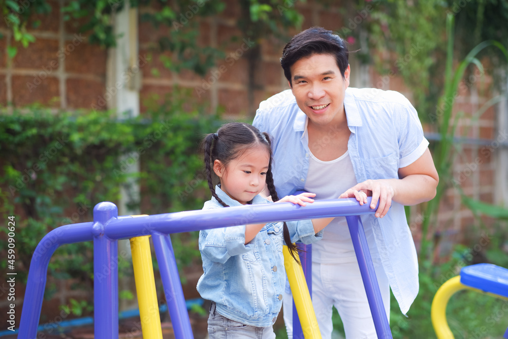 Happy asian family together with daughter in playground
