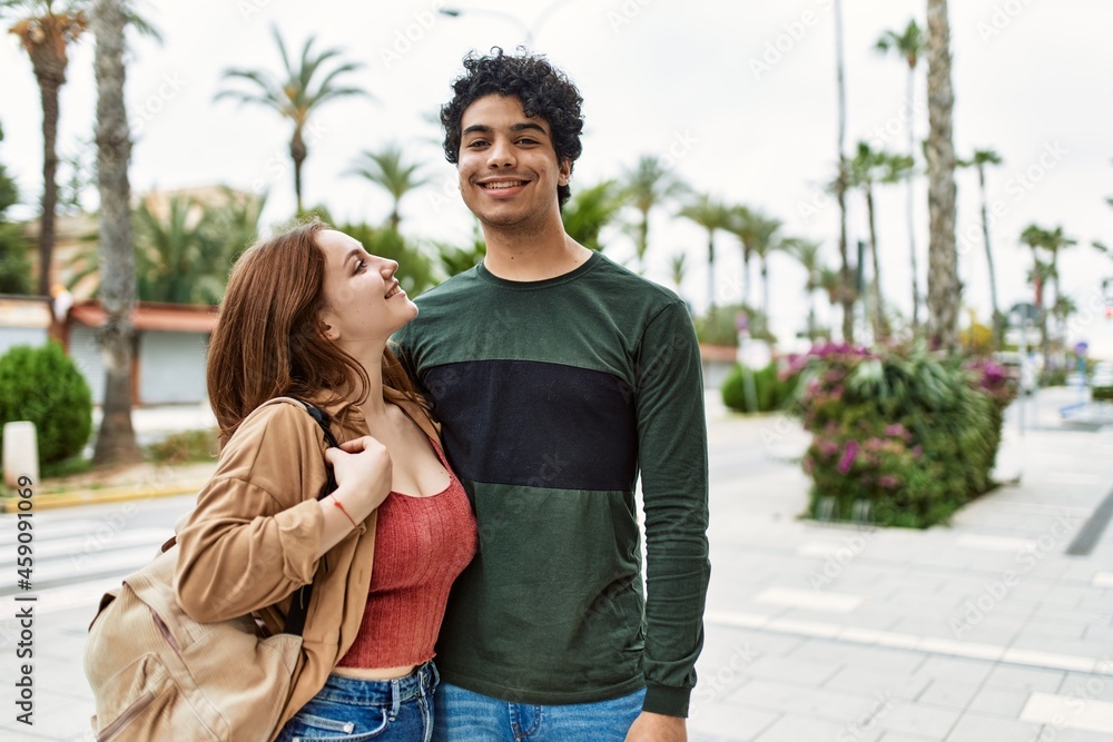 Fototapeta premium Young interracial couple smiling happy and hugging standing at the city.