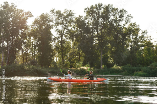 Kayak with young couple boating together on a lake surrounded by peaceful summer nature © Svitlana