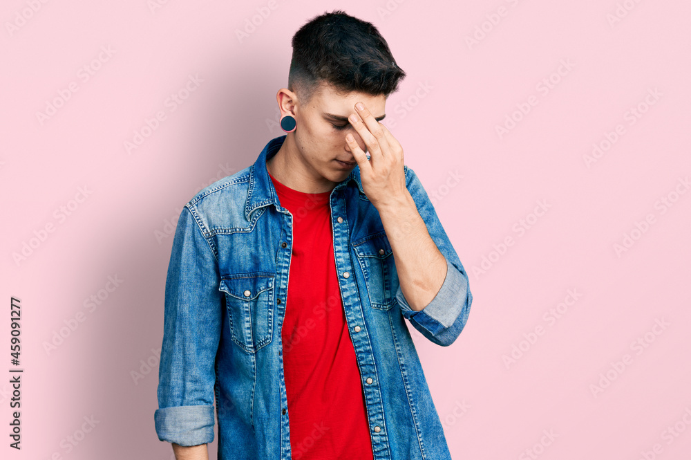 Young caucasian boy with ears dilation wearing casual denim jacket tired rubbing nose and eyes feeling fatigue and headache. stress and frustration concept. Young caucasian boy with ears dilation wearing casual denim jacket tired rubbing nose and eyes feeling fatigue and headache. stress and frustration concept.