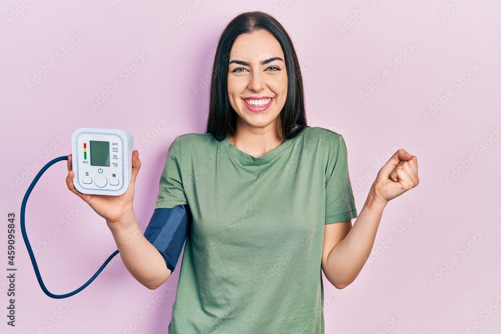 Beautiful woman with blue eyes using glucose meter screaming proud, celebrating victory and success very excited with raised arm Beautiful woman with blue eyes using glucose meter screaming proud, celebrating victory and success very excited with raised arm