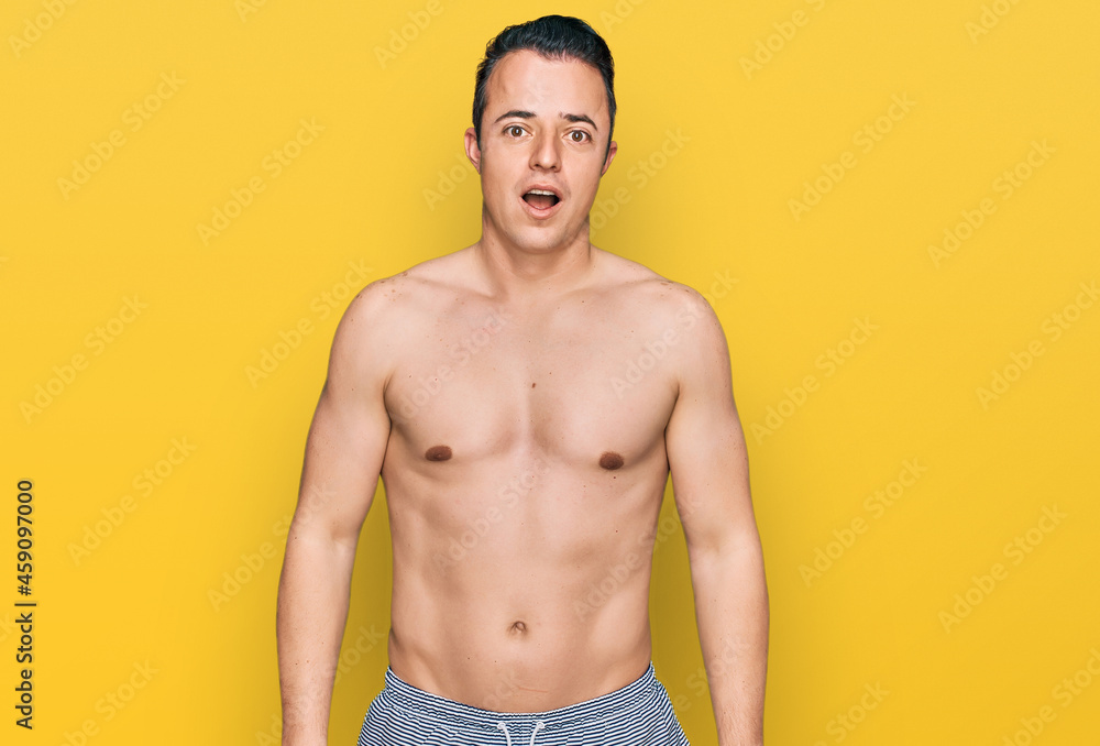 Fototapeta premium Handsome young man wearing swimwear shirtless afraid and shocked with surprise and amazed expression, fear and excited face.
