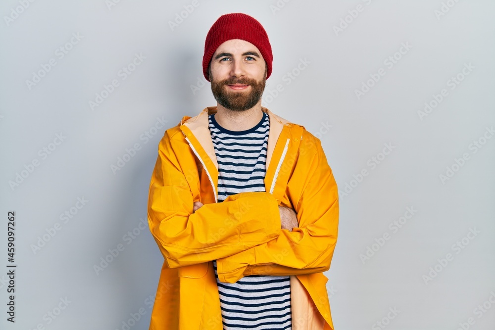 Caucasian man with beard wearing yellow raincoat happy face smiling with crossed arms looking at the camera. positive person. Caucasian man with beard wearing yellow raincoat happy face smiling with crossed arms looking at the camera. positive person.