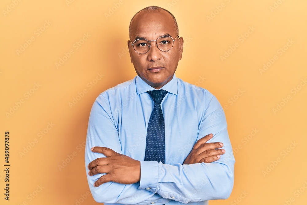 Middle age latin man wearing business clothes with arms crossed gesture relaxed with serious expression on face. simple and natural looking at the camera. Middle age latin man wearing business clothes with arms crossed gesture relaxed with serious expression on face. simple and natural looking at the camera.