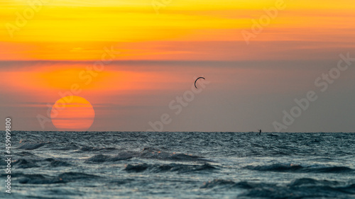 Fototapeta Naklejka Na Ścianę i Meble -  Kitesurfing on the water during the setting sun, Ameland, north sea, wadden sea 