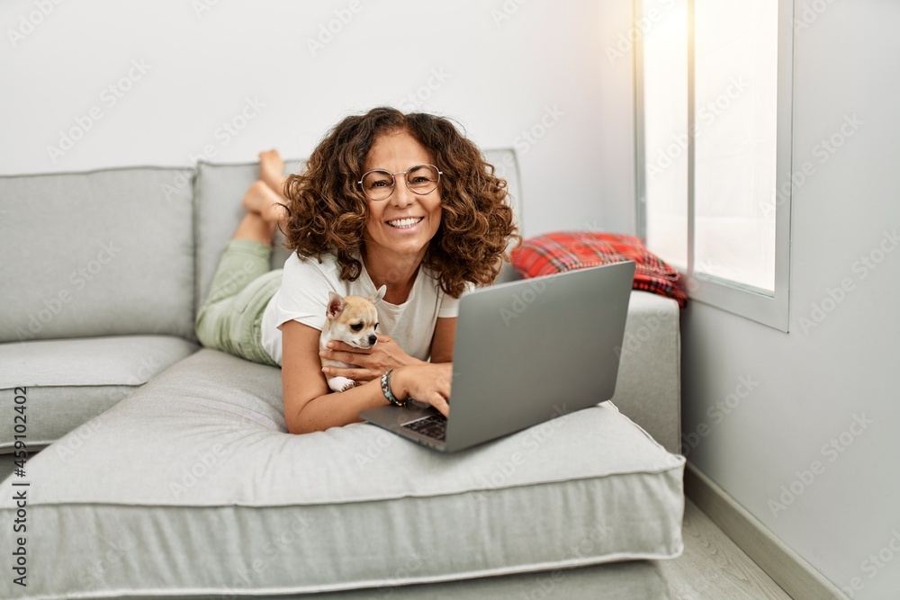 Middle age hispanic woman smiling confident using laptop at home Middle age hispanic woman smiling confident using laptop at home