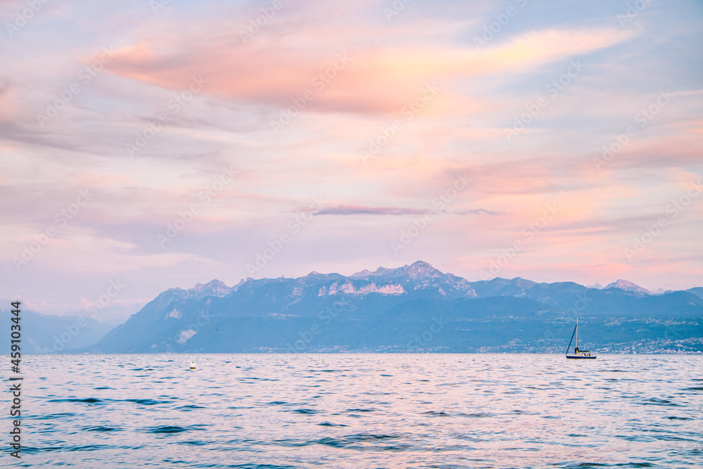 September sunset over the Geneva Lake (Lac Léman) and the mountains, next to the city of Lausanne in Morges in Switzerland with amazing sky colours after the golden hour, during the blue hour.