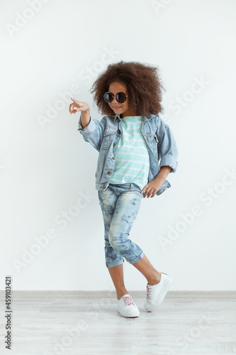 Beautiful stylish little girl in denim clothes