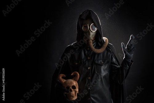 Post-apocalyptic world, concept. A gloomy servant of the devil cult in a black hood photo