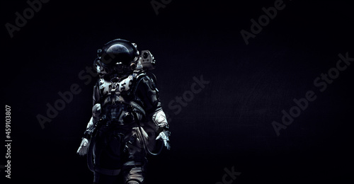 Astronaut in suit against black background. Space technology concept . Mixed media