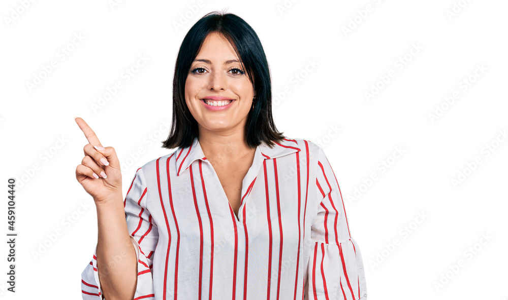 Young hispanic girl wearing casual clothes with a big smile on face, pointing with hand finger to the side looking at the camera. Young hispanic girl wearing casual clothes with a big smile on face, pointing with hand finger to the side looking at the camera.