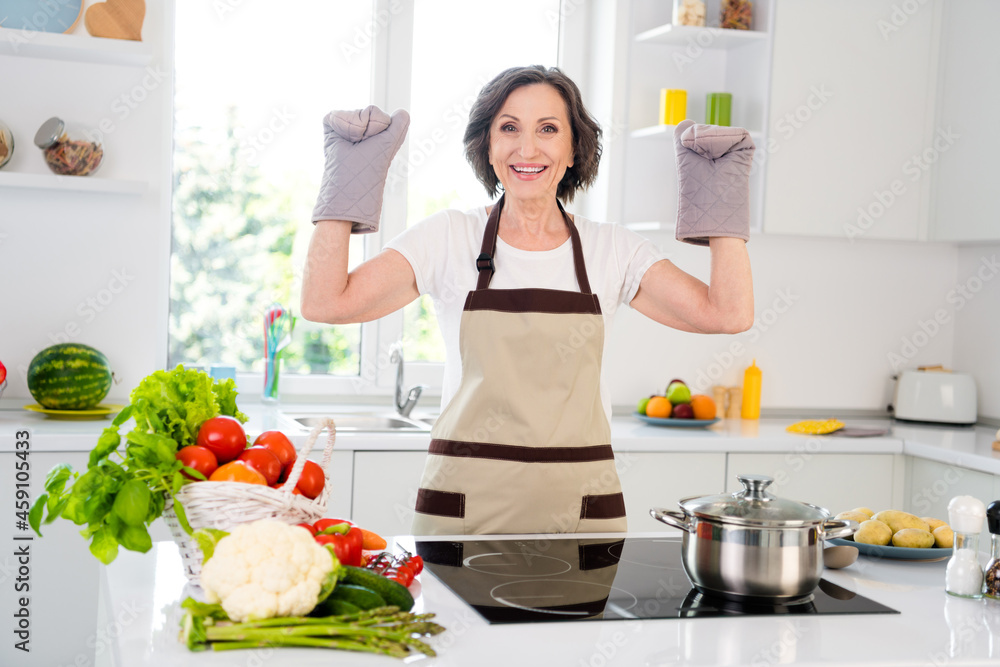 Photo of funky age brunette lady cook wear gloves apron white t-shirt at kitchen alone