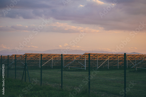 field with solar panels on a background of mountains