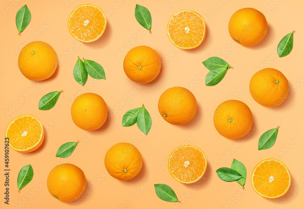Fruit pattern arranged of oranges and orange leaves on yellow background. Lay out background. Fruit pattern arranged of oranges and orange leaves on yellow background. Lay out background.