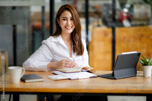 Portrait of Beautiful young smiling Asian entrepreneur businesswoman working whit laptop computer in modern office.